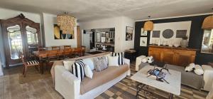 a living room with a couch and a dining room at The Lily House Hermanus - Central Private Cottages in Hermanus