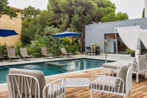 a pool with chairs and umbrellas on a wooden deck at Best Western Hotel Casa Bianca, Piscine Intérieure et Extérieure in Calvi