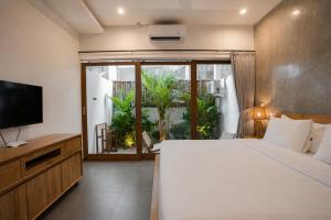 a bedroom with a large bed and a television at Suksma Guesthouse in Canggu +44 photos