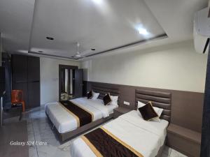 a hotel room with two beds in a room at Hotel Saffron in Vadodara