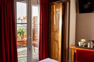 a room with a red curtain and a door at Hotel Des Deux Continents in Paris