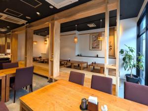 a conference room with wooden tables and chairs at Green Rich Hotel Izumo (Artificial hot spring Futamata Yunohana) in Izumo