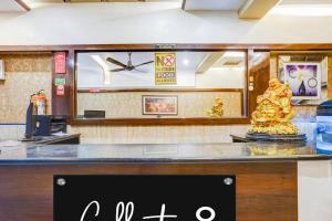 a store counter with a clock and a statue at Super Collection O Sindhi Camp Formerly Hotel Abhinandan Inn in Jaipur