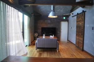 a living room with a couch and a table at Beringei house Kujukuri in Katakai