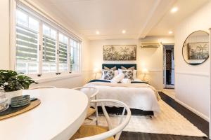 a bedroom with a bed and a table and chairs at Urban Getaway Apartment Ipswich in Ipswich
