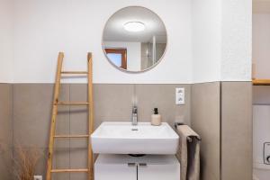 a bathroom with a sink and a mirror at Ferienhaus Schmuckstück in Schiltach
