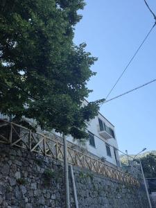 a building on top of a stone wall with a tree at Ravello Sky & Sea in Ravello