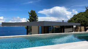 a house with a swimming pool next to the water at Ukino House in Nikiana