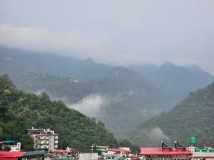 a group of buildings in front of a mountain at Hariom Stay Rishikesh in Rishīkesh