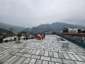 a group of people sitting on top of a roof at Hariom Stay Rishikesh in Rishīkesh