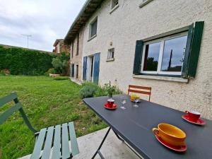 a black table with two plates and two chairs at Maison de campagne - Granges sur Lot in Granges-sur-Lot