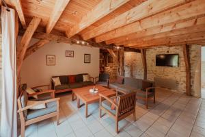 a living room with wooden ceilings and a table and chairs at Les instants du lot in Trespoux-Rassiels