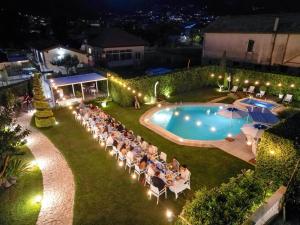 a group of people sitting in chairs by a pool at night at Divina Costiera in Agerola