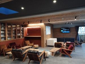 a lobby with chairs and tables and a television at Vila Plamenac in Divčibare