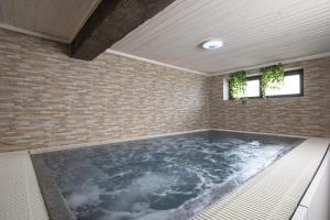 a hot tub in a room with a brick wall at Mountain Escape house with indoor pool in Fužine