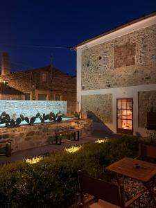 a patio with a table and a building at night at Vento Forte - eco dimore nel borgo in Civita