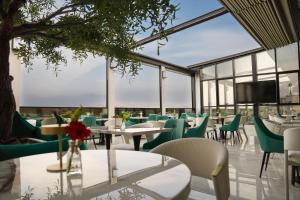 a restaurant with tables and chairs and a flat screen tv at KH La Maison in Abha