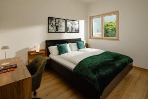 a bedroom with a bed and a desk and a window at Rauchhof Apartments in Auer