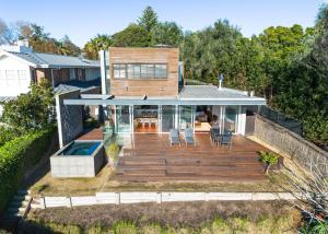 a house with a large deck with a swimming pool at Emanjay - Mineral Spa, Million Dollar Views in Mount Martha