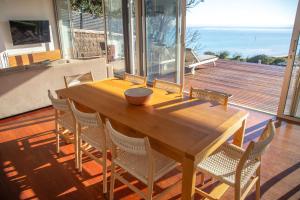 a dining room table with chairs and a view of the ocean at Emanjay - Mineral Spa, Million Dollar Views in Mount Martha