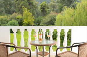 two glasses of wine sitting on a table on a balcony at Mitsis Galini in Kamena Vourla