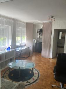 a living room with a glass table and a kitchen at Evelyn in Emmelshausen
