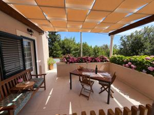 a patio with a table and chairs and flowers at Villa Fragola 3 in Doli