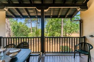 a porch with a table and chairs and a large window at Golf de Biscarrosse – Piscine in Biscarrosse