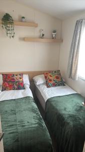 a room with two beds in a room at Luxury Family Caravan St Osyth Beach Clacton on Sea in Saint Osyth +23 photos