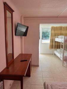 a living room with a mirror and a tv on the wall at Hôtel Le Robinson in Beaucaire