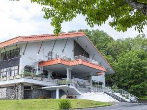 a white building with a red roof at 黒姫高原ホテル in Shinano