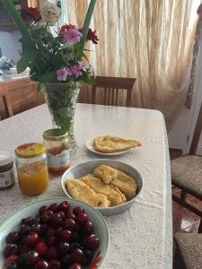 a table with a bowl of grapes and a plate of food at Templa in Himare