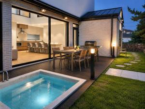 a patio with a table and a swimming pool at The Brighton Hamdeok in Jeju