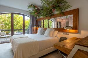 a bedroom with a bed and a desk and a window at Hotel Cuevas - Adults Only in Santillana del Mar