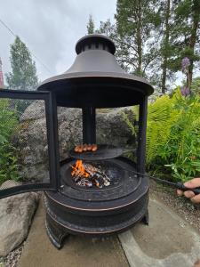 a fire pit with a bell on top of it at Stockboden Kvarken Off Grid Cabin No Electricity or Running Water in Oravais