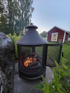 a outdoor grill with a fire in a yard at Stockboden Kvarken Off Grid Cabin No Electricity or Running Water in Oravais
