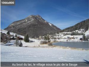 a mountain in front of a lake with snow on the ground at pas dispo moins de 5 nuits Ecogite du lac in La Thuile