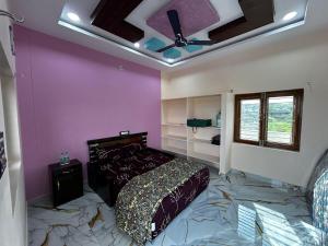 a bedroom with a bed and a ceiling fan at Ros Villa in Vikārābād +20 photos
