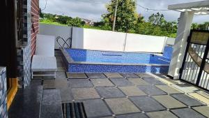 a swimming pool on a patio with a bench at Ros Villa in Vikārābād