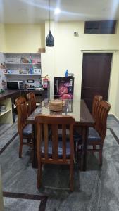 a dining room table with chairs and a table and a counter at Ros Villa in Vikārābād