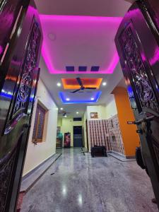 an empty room with purple lights on the ceiling at Ros Villa in Vikārābād