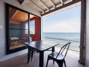 a dining room with a table and chairs and the ocean at Costa Del Sol HIJI in Hiji