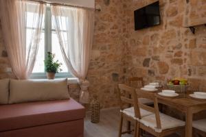 a living room with a table and a couch at Amalthea Guest House in Egina