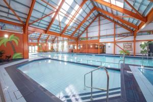 a large indoor swimming pool with a large ceiling at Luxury Family Caravan St Osyth Beach Clacton on Sea in Saint Osyth