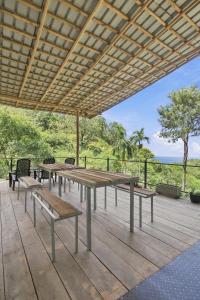 a picnic table and benches on a wooden deck at Jungle Nest Ella in Ella
