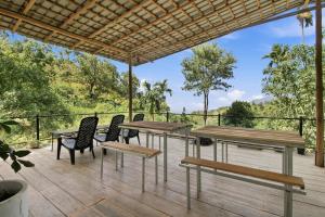 a patio with wooden tables and chairs on a deck at Jungle Nest Ella in Ella