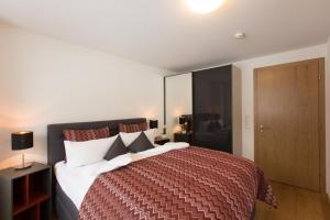 Un dormitorio con una cama grande con una manta roja. en Appartement-Ennemoser, en Mellau