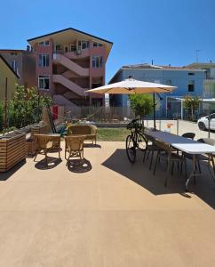 a patio with tables and chairs and an umbrella at mansarda fronte mare in Potenza Picena