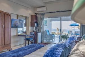 a living room with a bed with blue pillows at Bentley on the Beach in Umhlanga