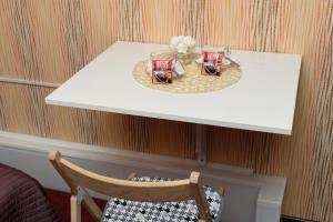 uma mesa branca com duas chávenas e uma cadeira em Teremok em Dimitrovgrad